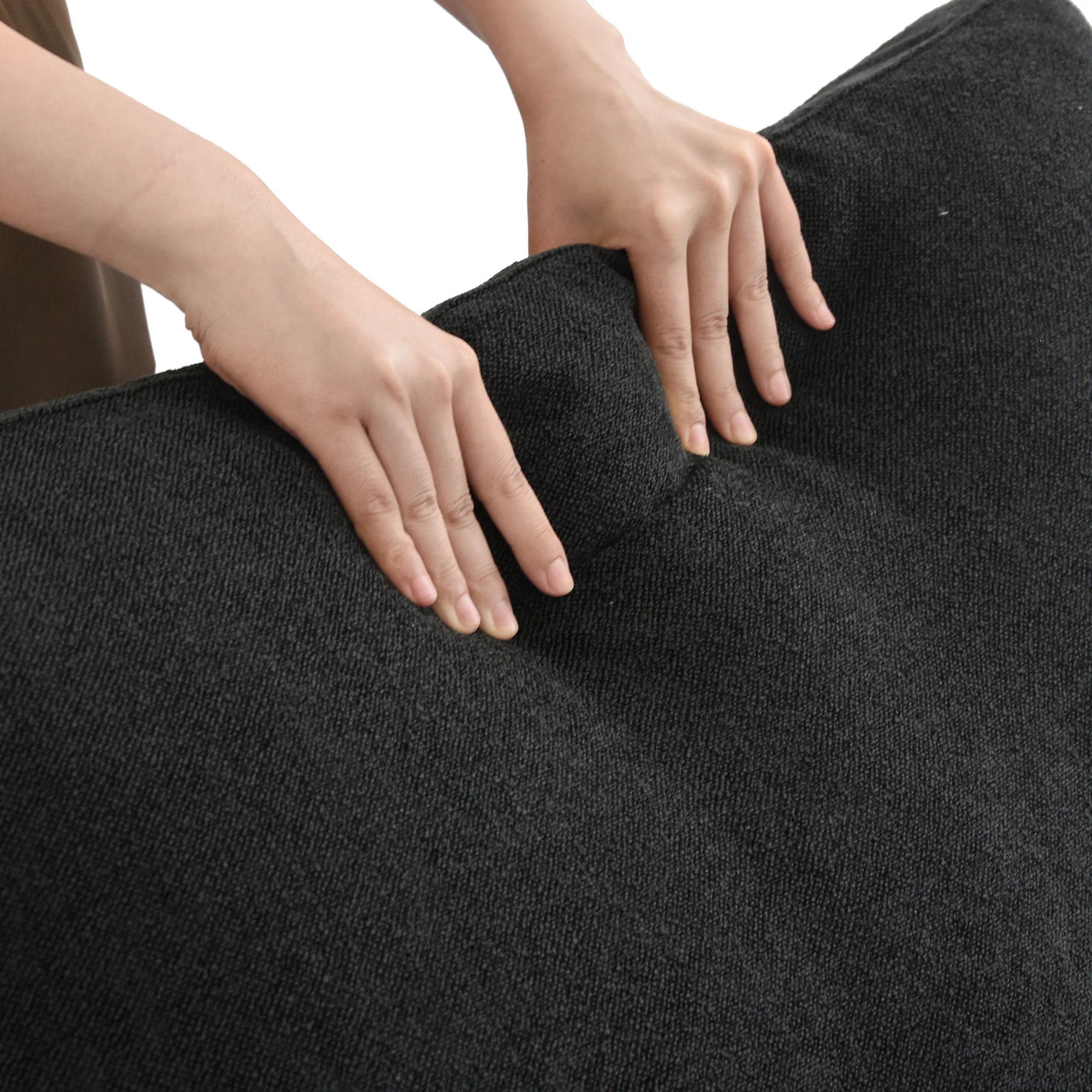 Extra Cover Set in Black — close-up of the boucle weave as hands press into the cushion